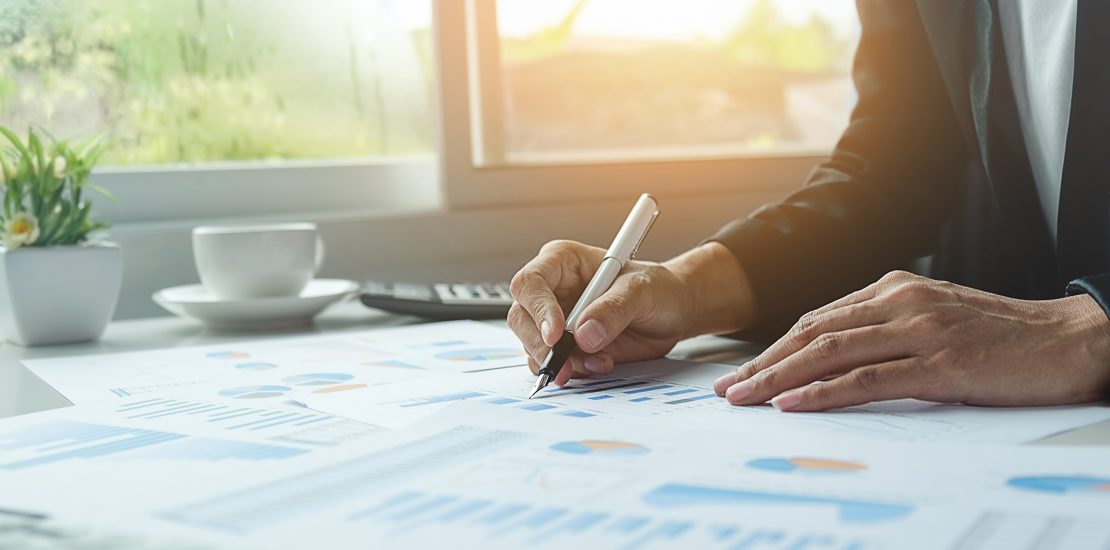 Asian business woman analyzing investment charts on desk. Vintage tone Retro filter effect,soft focus,low light.(selective focus).